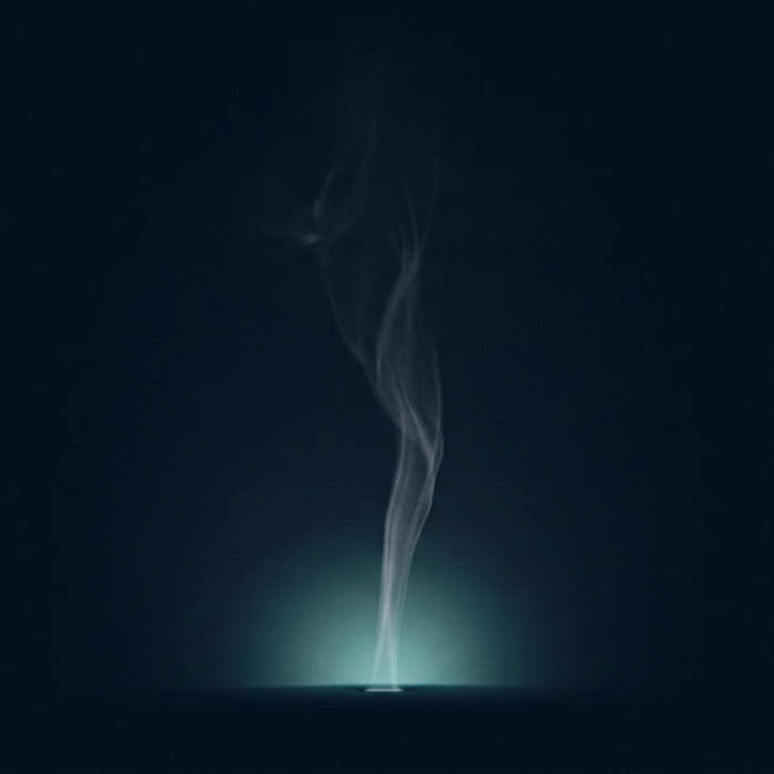 Artistic white smoke wisp rising straight up from a light source against a dark background